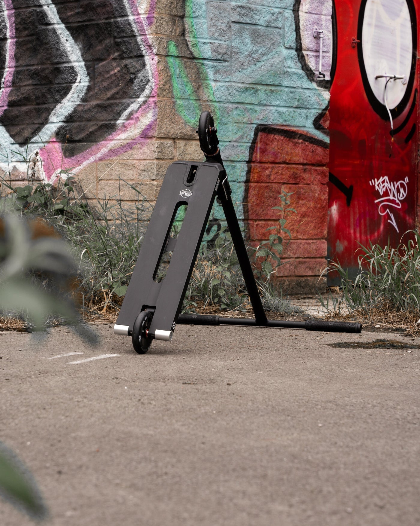 CORE ST2 Stunt Scooter Black I Adult Stunt Scooter Leaning by Wall